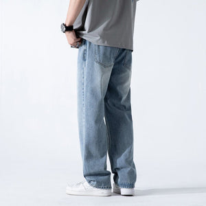 Light blue vintage men's jeans with a loose straight fit, washed wide-leg denim trousers, shown on a model.