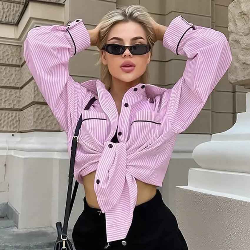 Loose striped shirt top with long sleeves and relaxed fit, featuring bold vertical stripes in various colors.